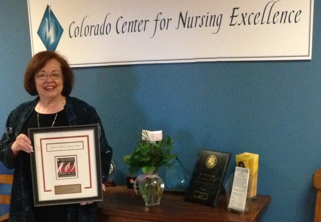 Karren Kowalski holds an award